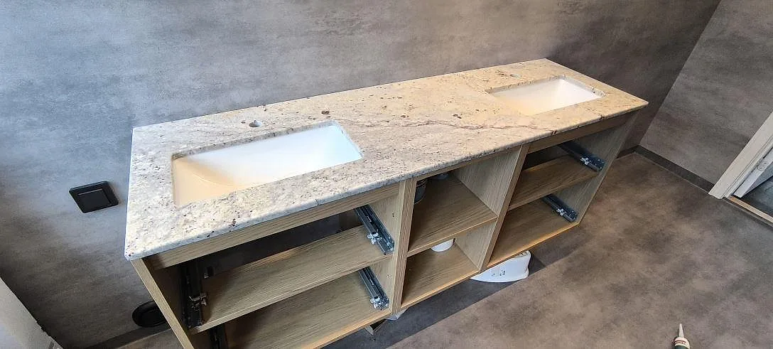 Badrumsbänkskiva i Antique White granit, poleret, med två underlimmade tvättställ på träinredning i Strängnäs.