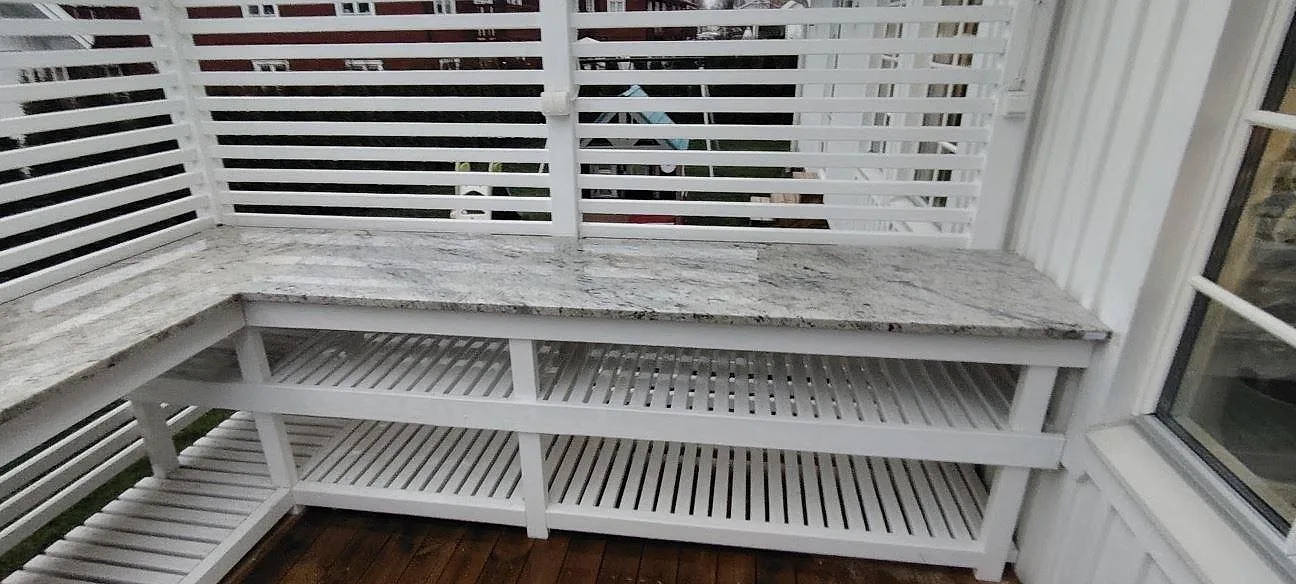 Poleret vindueskarm i Antique White granit, 30 mm, monteret som lang avställningsyta vid ett vindue i Vendelsö.