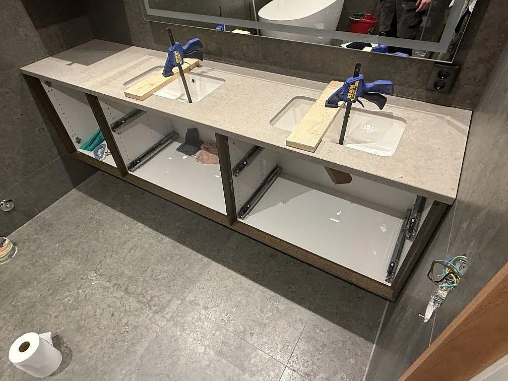 Badrumsbänkskiva i mat Azul Valverde kalksten med två underlimmade vita tvättställ på en dubbelkommod i Västervik.