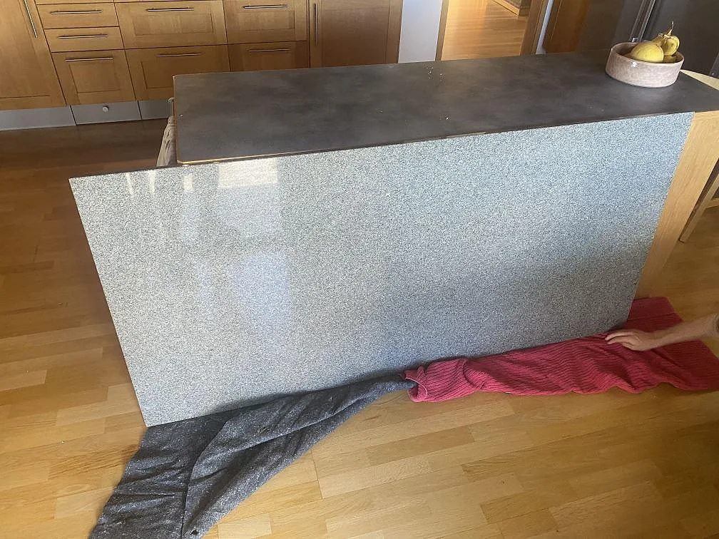 Køkkenbordplade i poleret Bohus Grå granit på en fristående køkkenø med spräcklig grå overflade i ett køkken i Askim.