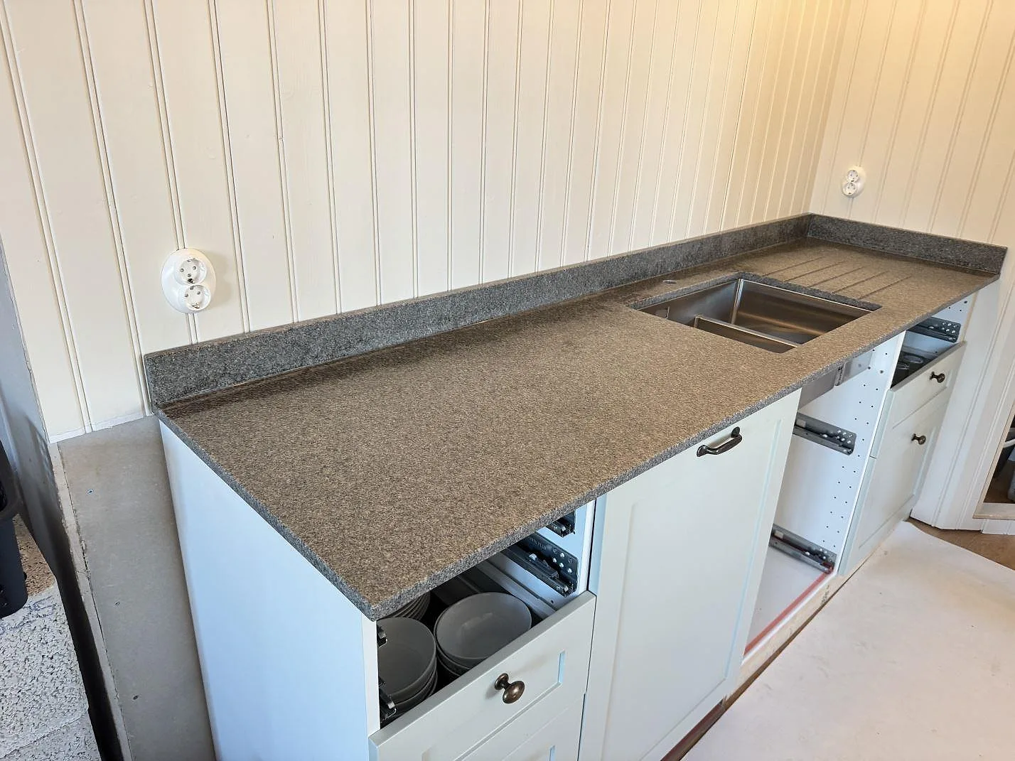 Køkkenbordplade i Bohus Grå granit, mat overflade, med underlimmad rostfri vask i ett kustnära køkken i Slöinge under montering.