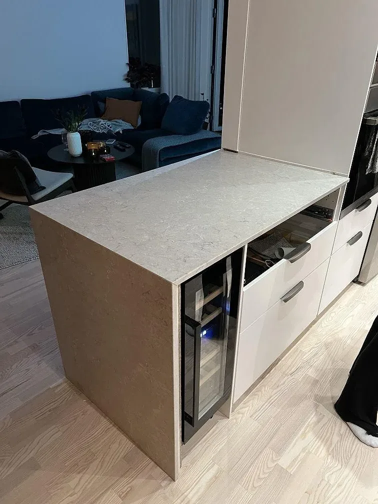 Köksödel med poleret Caesarstone Bianco Drift i lys kvartskomposit i ett køkken i Uppsala under montering.