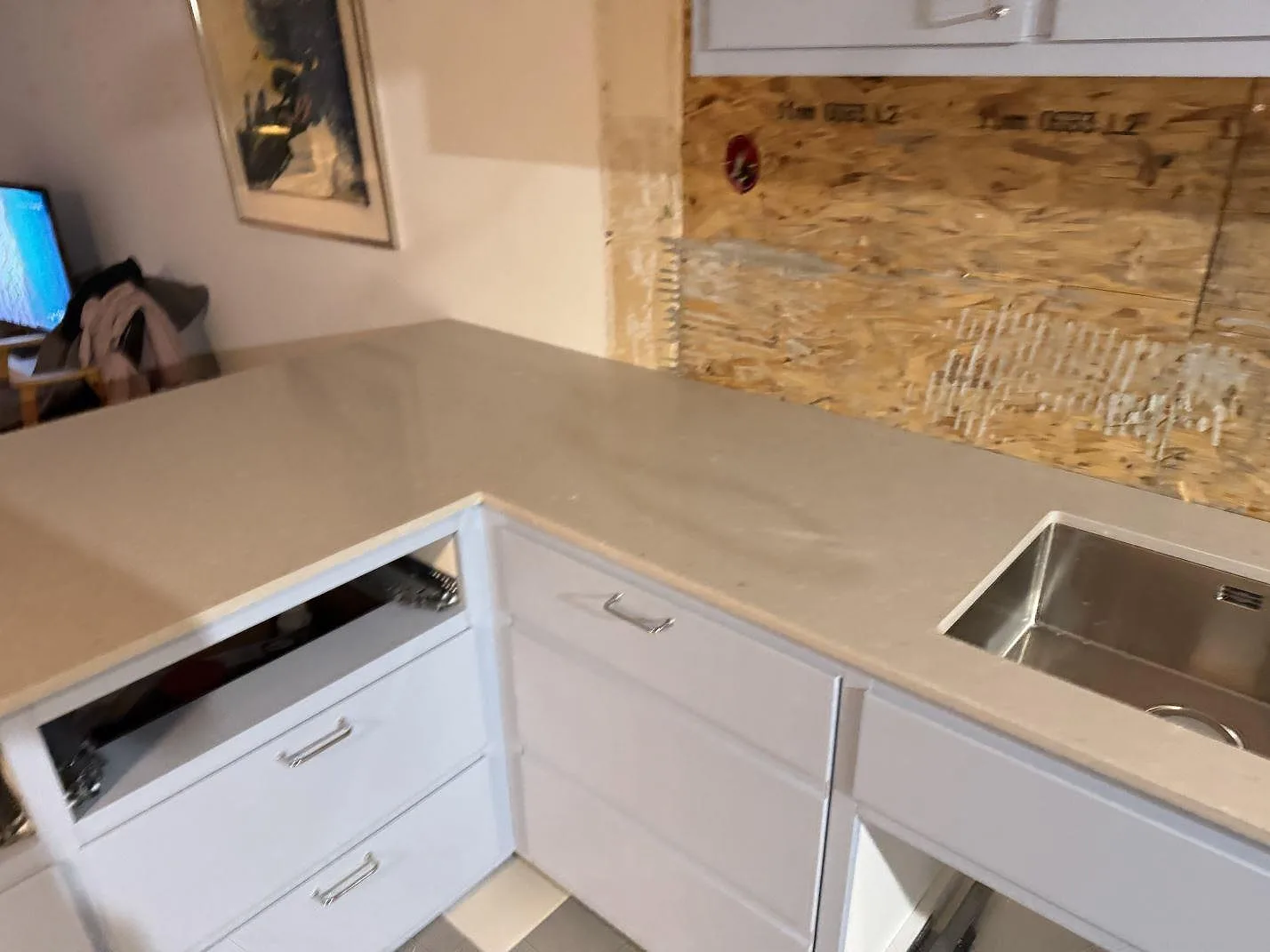 Køkkenbordplade i Caesarstone Clamshell, poleret kvartskomposit, med rostfri vask og öppen köksstomme i Malmö.