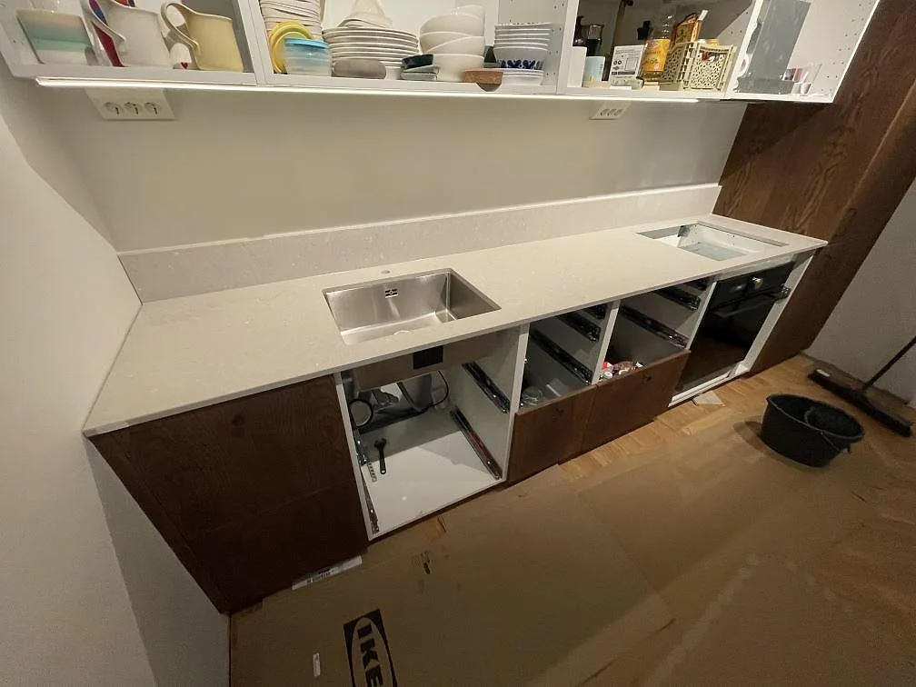 Køkkenbordplade i mat Caesarstone Clamshell, komposit, med rostfri vask, låg stänkkant og hälluttag i ett køkken i Stockholm.