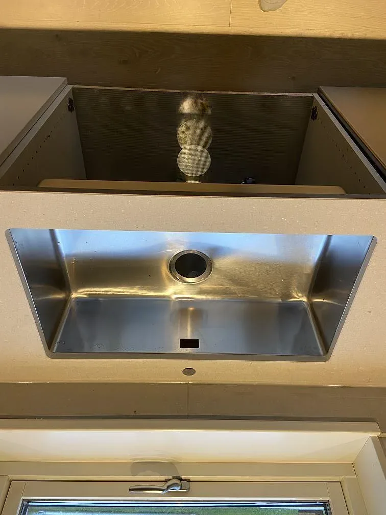 Køkkenbordplade i beige Caesarstone Clamshell, mat, med underlimmad rostfri vask og Armaturhul i ett køkken i Varberg.