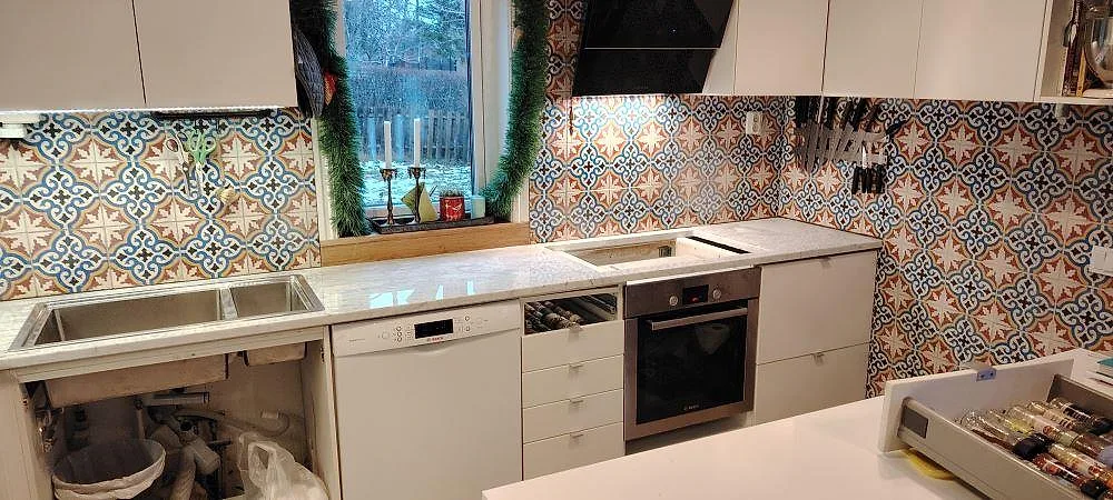Køkkenbordplade i Carrara C marmor, 30 mm med mat og poleret finish angiven, med diskzon og hällzon foran kaklat stænkplade i Ekerö.