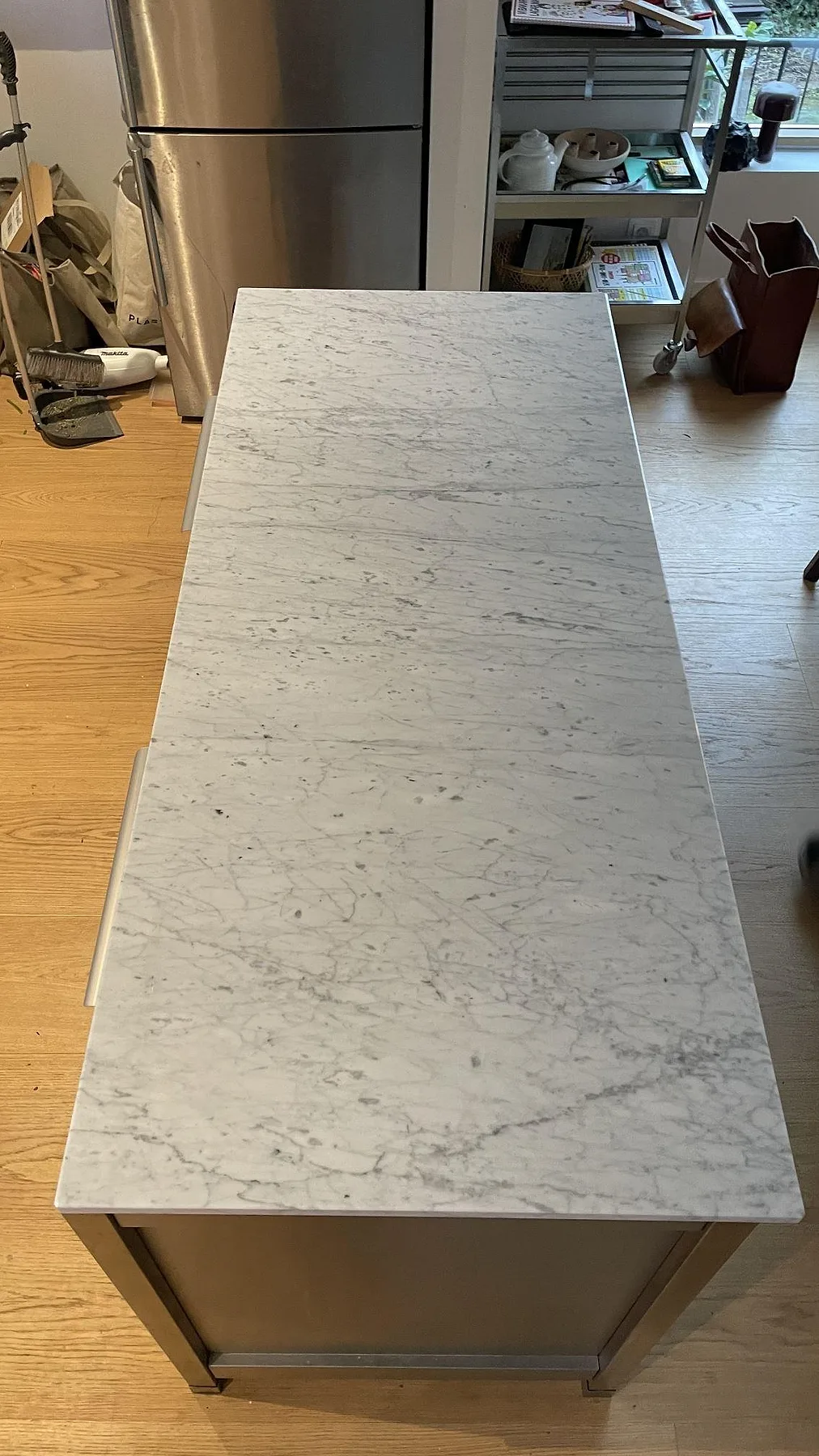 Poleret køkkenbordplade i Carrara C marmor, 20 mm, med grå åretegning på en fristående köksyta i Limhamn.