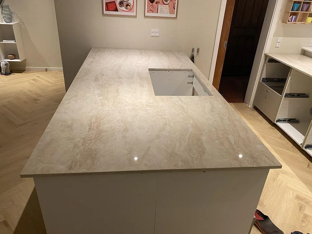 Køkkenbordplade i poleret Dekton Arga, keramisk sten, med bred bänkyta og rektangulärt udskæring i ett køkken i Egå.