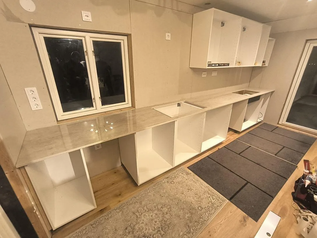 Køkkenbordplade i poleret Dekton Arga, 20 mm, monteret på vita köksstommar i Torsåker.