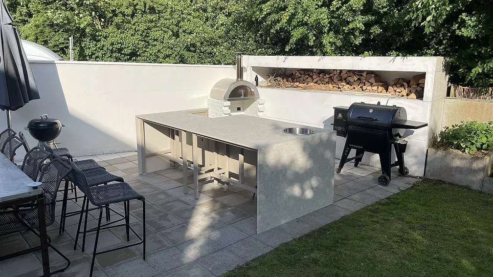 Utomhuskök i Helsinborg med Bordplade i mat Dekton Ava, rund rostfri vask og lys keramisk overflade på uteplatsen.