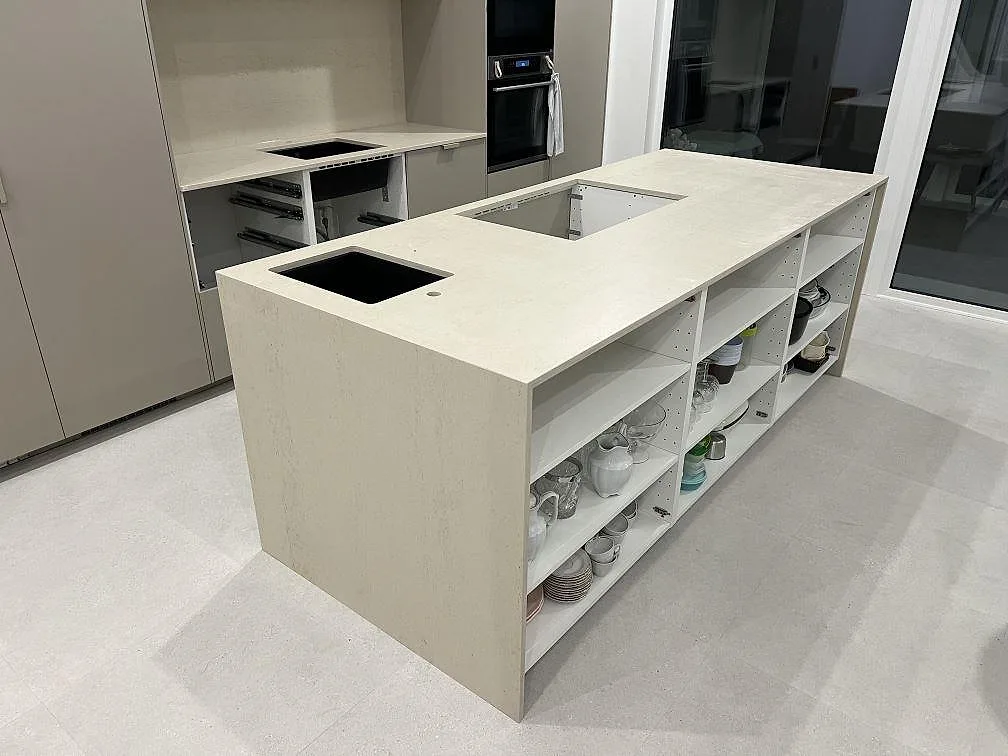 Køkkenø med køkkenbordplade i mat Dekton Danae, beige keramik, med vattenfallssida og förberedda öppningar i ett køkken i Stockholm.