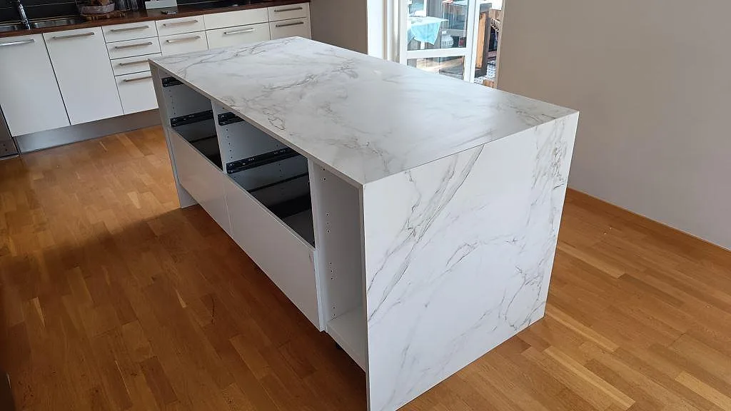 Køkkenø med køkkenbordplade i mat Dekton Entzo, 20 mm hvid keramik med grå åretegning, monteret i ett køkken i Staffanstorp.