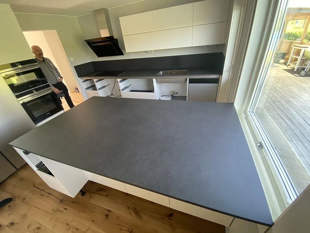 Køkkenbordplade og køkkenø i Dekton Eter i mat mockafinish i ett køkken i Strövelstorp, fotograferat under montering.