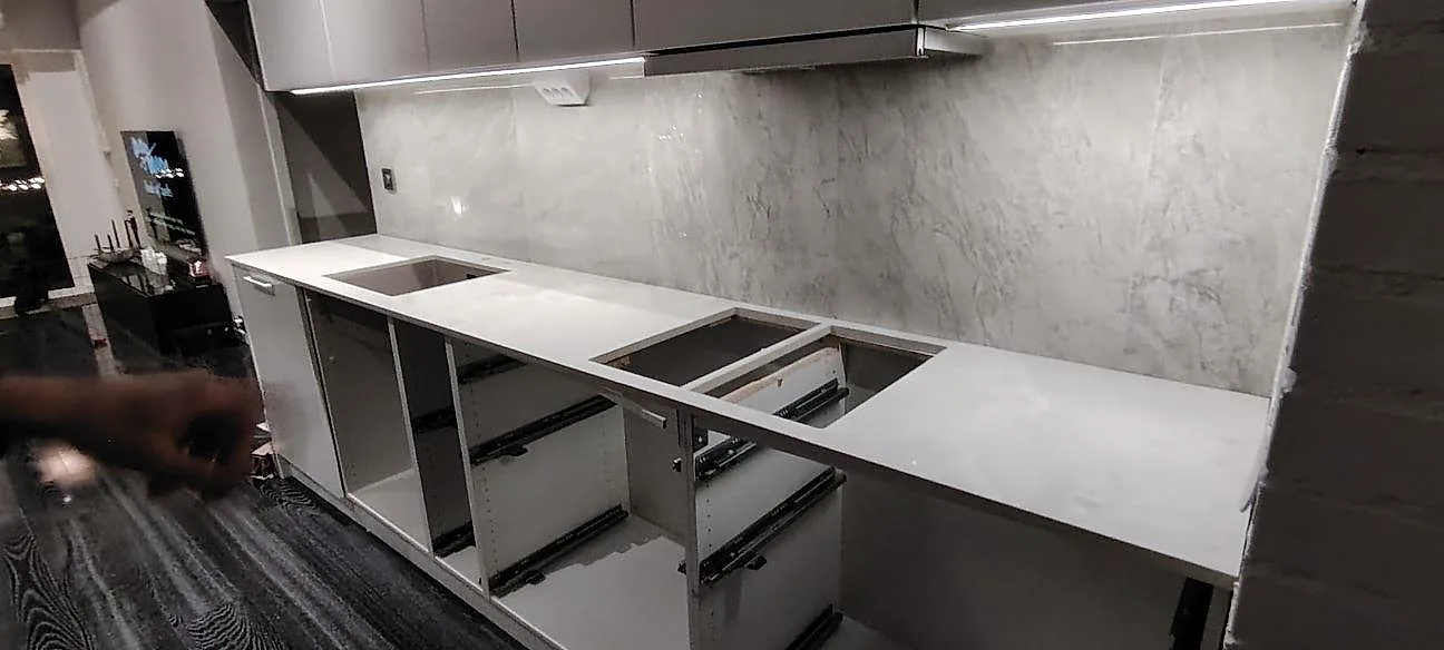 Køkkenbordplade i poleret Dekton Helena, 20 mm, monteret på en lang köksrad med halvö under montering i Gävle.