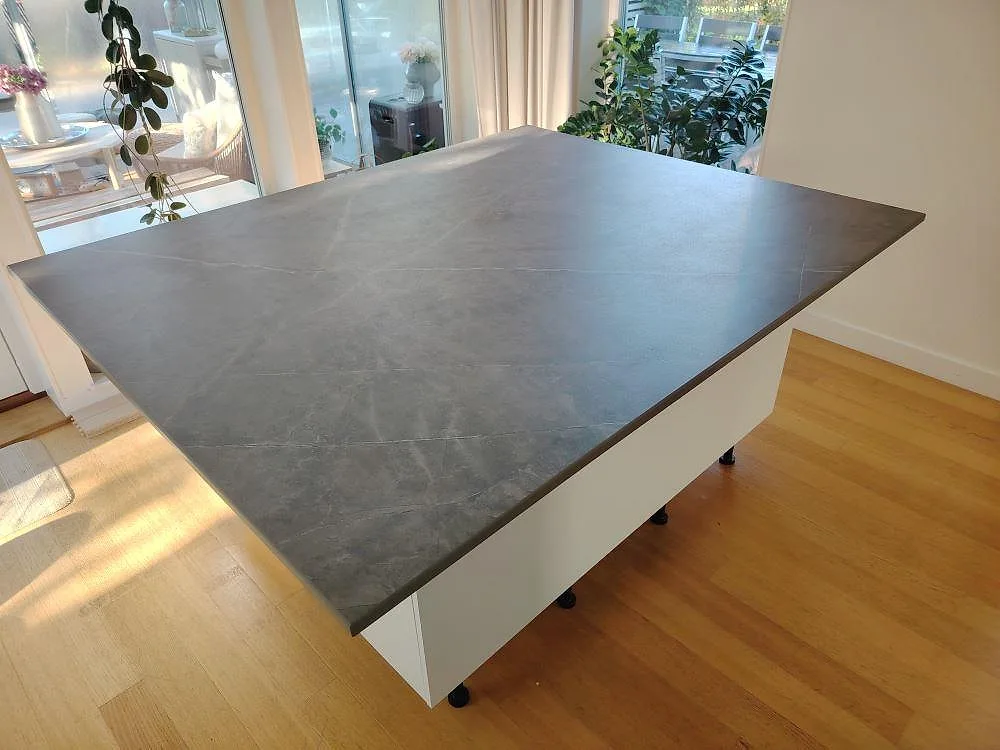 Køkkenø med Bordplade i mörkgrå mat Dekton Kira, 20 mm, som sammanhängande arbetsyta i ett køkken i Vendelsö.