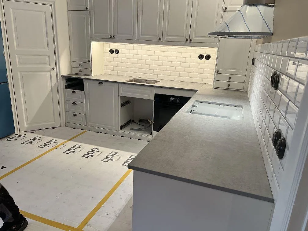 Køkkenbordplade i mat Dekton Kreta, 20 mm, med grå betongliknande overflade i ett ljust køkken i Stockholm.