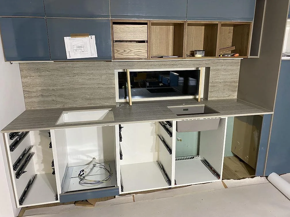 Køkkenbordplade i mat Dekton Nebu, keramik i 20 mm, med matchande stænkplade og vægbeklædning i ett køkken under montering i Borrby.