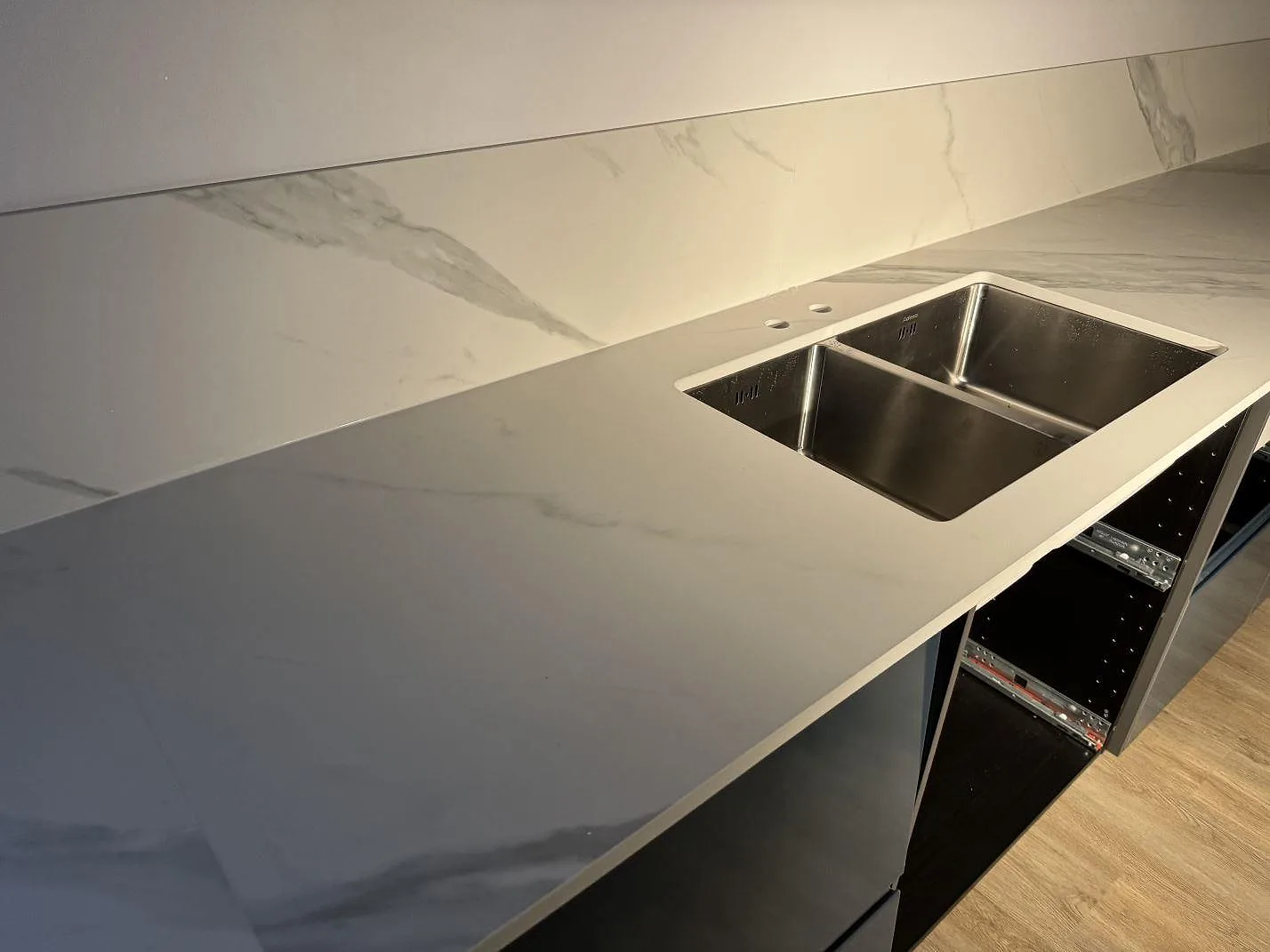 Køkkenbordplade i mat Dekton Opera Velvet med rostfri dubbelho og stænkplade i ett køkken i Malmö.