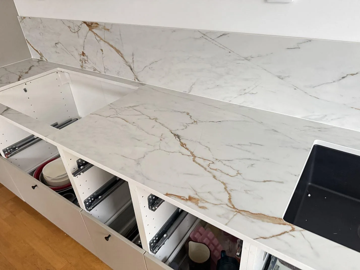 Køkkenbordplade i mat Dekton Reverie med 8 mm stænkplade og sort vask i ett køkken i Oxie.