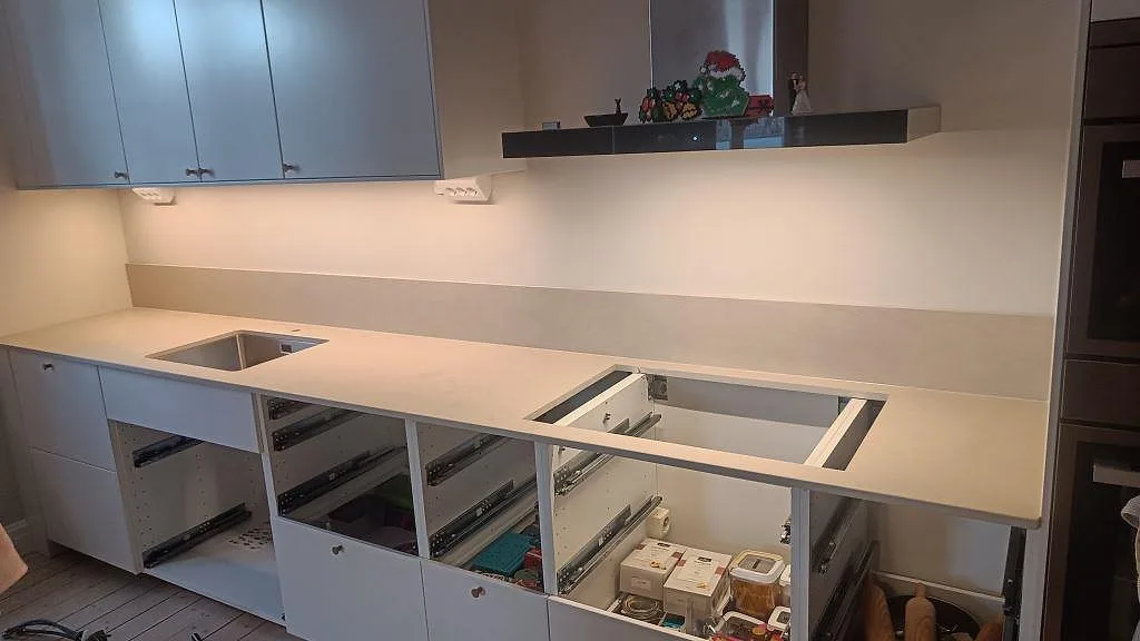Køkkenbordplade i Dekton Sasea, mat grågrön tone, med underlimmad rostfri vask og uppvikt stänkkant i ett køkken i Malmö.