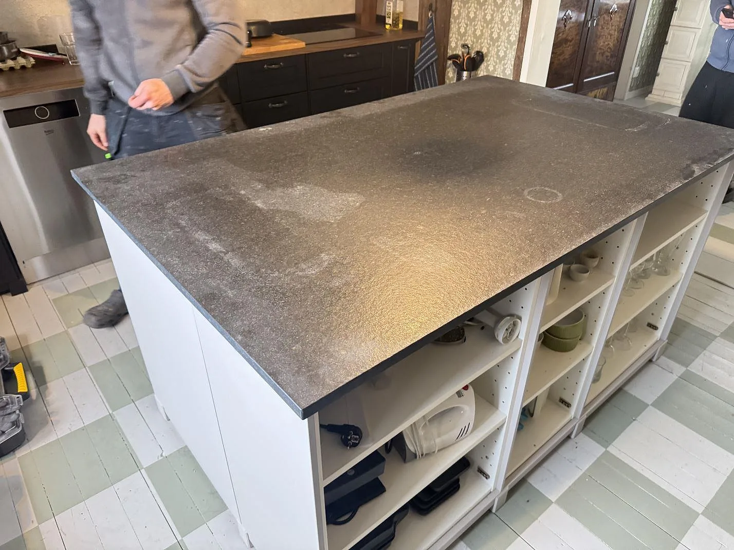 Køkkenø med Bordplade i Nero Assoluto Flamed and Brushed granit, mat strukturerad overflade, monteret i ett køkken i Vara.