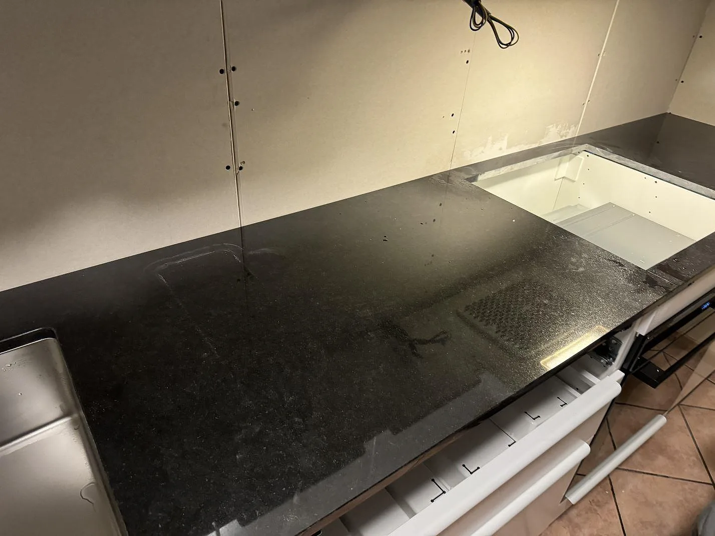 Poleret køkkenbordplade i Nero Assoluto granit med rostfri vask og hällöppning i ett køkken i Oxie.