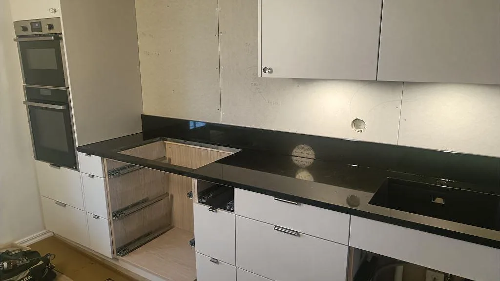 Poleret køkkenbordplade i sort granit Nero Assoluto med låg stänkkant og udskæring for köksinstallationer i Tibro.