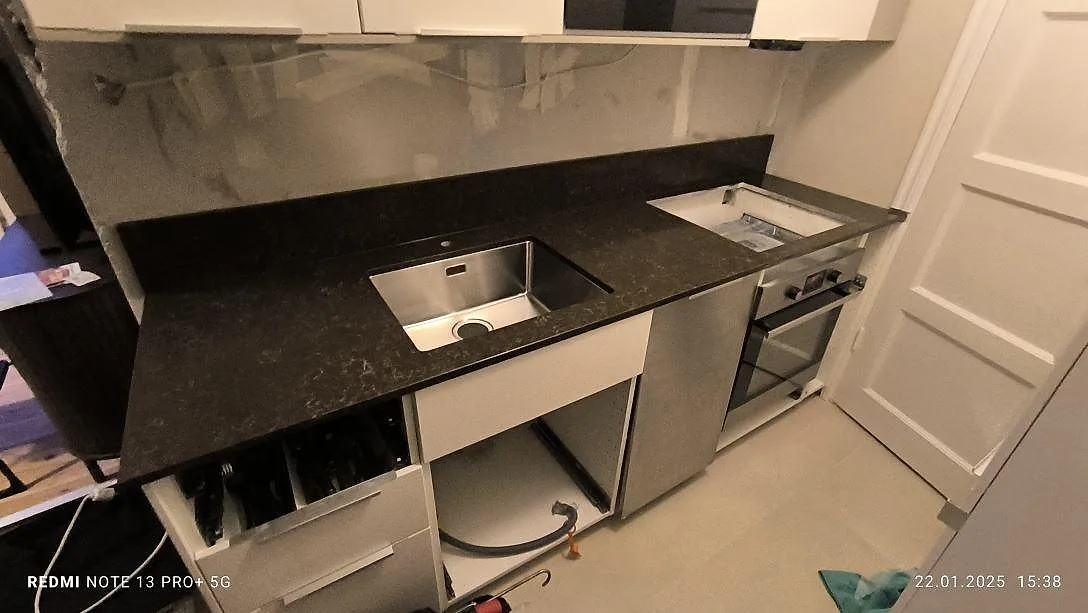 Poleret køkkenbordplade i mörkbrun Technistone Noble Athos Brown kvartskomposit med underlimmad rostfri vask og hälluttag i Stockholm.