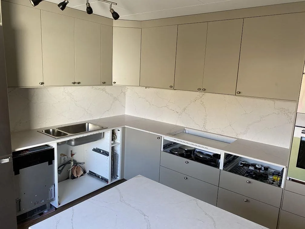 Køkkenbordplade i mat Silestone Blanc Elysee komposit med matchande stænkplade i ett køkken i Vinslöv.