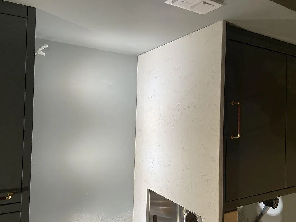 Køkkenbordplade i hvid Silestone Blanco Orion, poleret kvartskomposit med grå åretegning, med underlimmad rostfri vask og plats for kogeplade i ett køkken i Åhus.