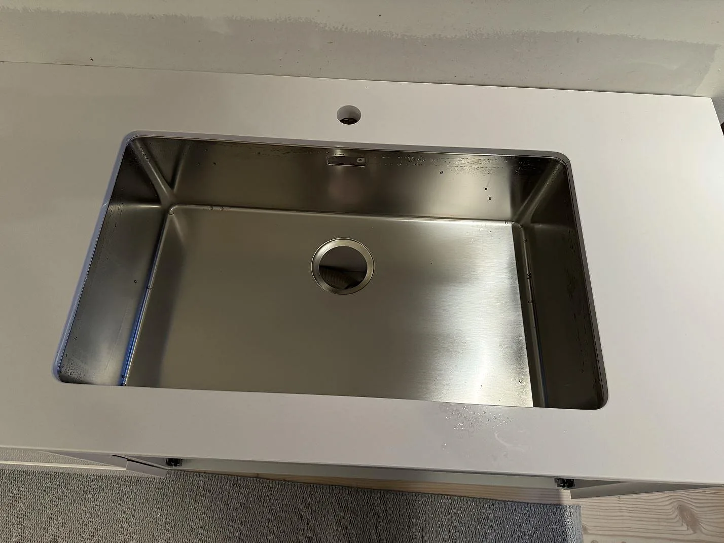 Närbild af underlimmad rostfri vask i poleret hvid Silestone Blanco Zeus Extreme køkkenbordplade i Limhamn.