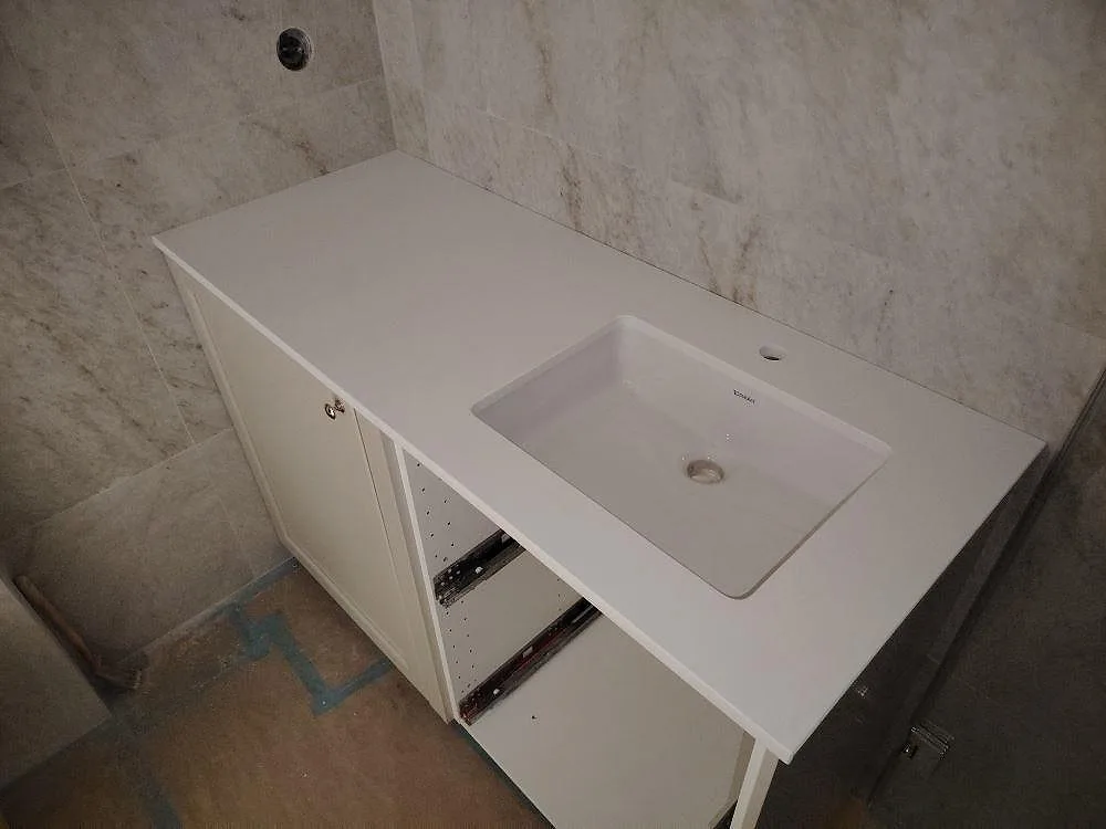 Badrumsbänkskiva i hvid Silestone Blanco Zeus, poleret komposit, med tvättställ i ett Badeværelse i Stockholm.