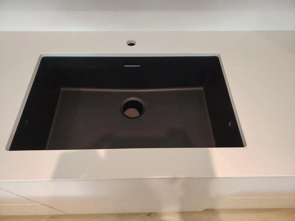 Mørk vask monteret i hvid poleret Silestone Blanco Zeus køkkenø med Armaturhul i Västerås.