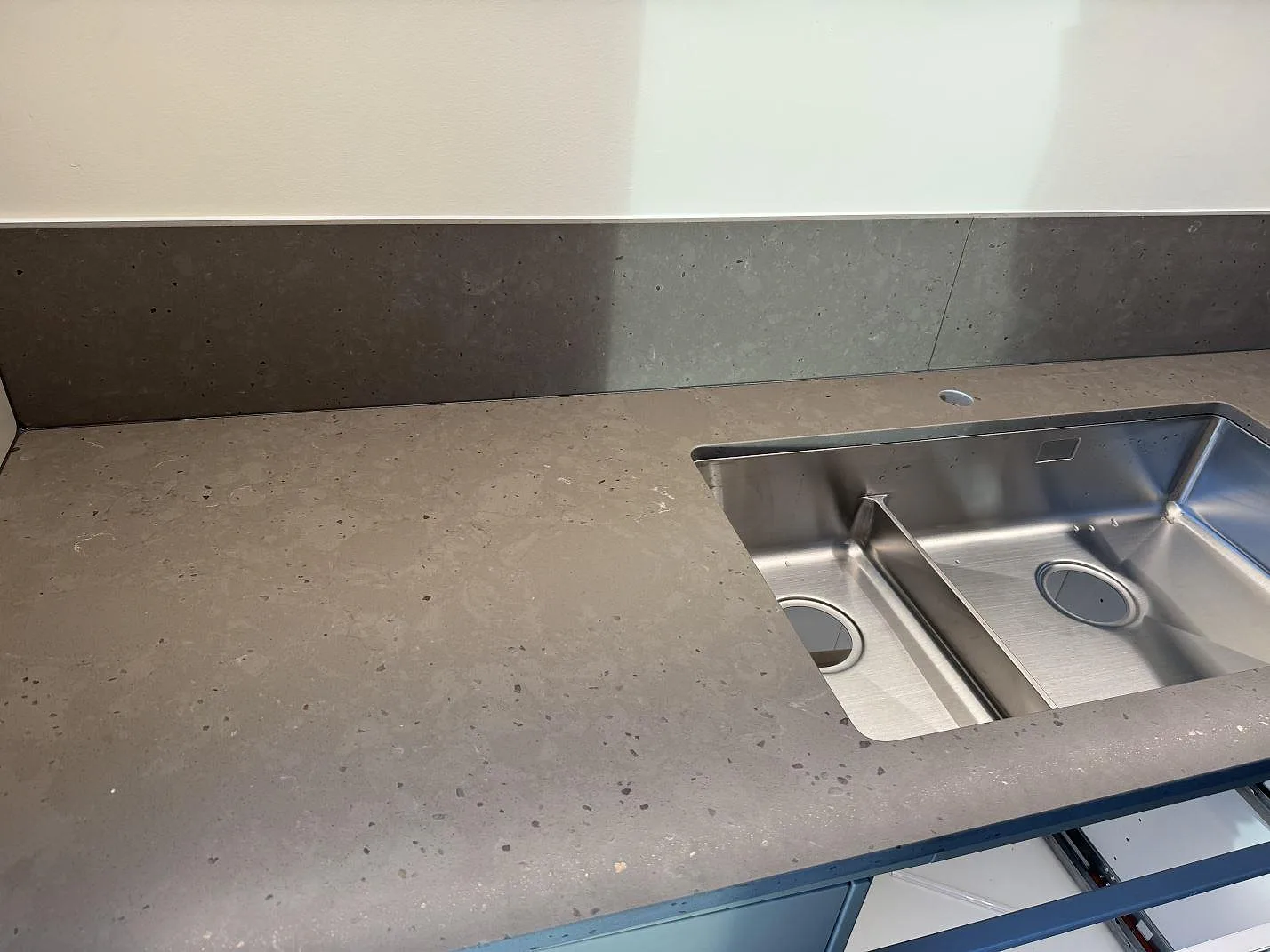 Køkkenbordplade i Silestone Brass relish, mat Mocka-overflade, med låg stänkkant og synlig rostfri vask i ett køkken i Göteborg.
