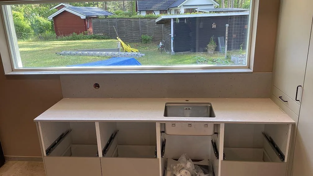 Bordplade i lys Silestone Concrete Pulse, mat Mocka-finish, med rostfri vask og stænkplade i en tvättstuga i Åhus.