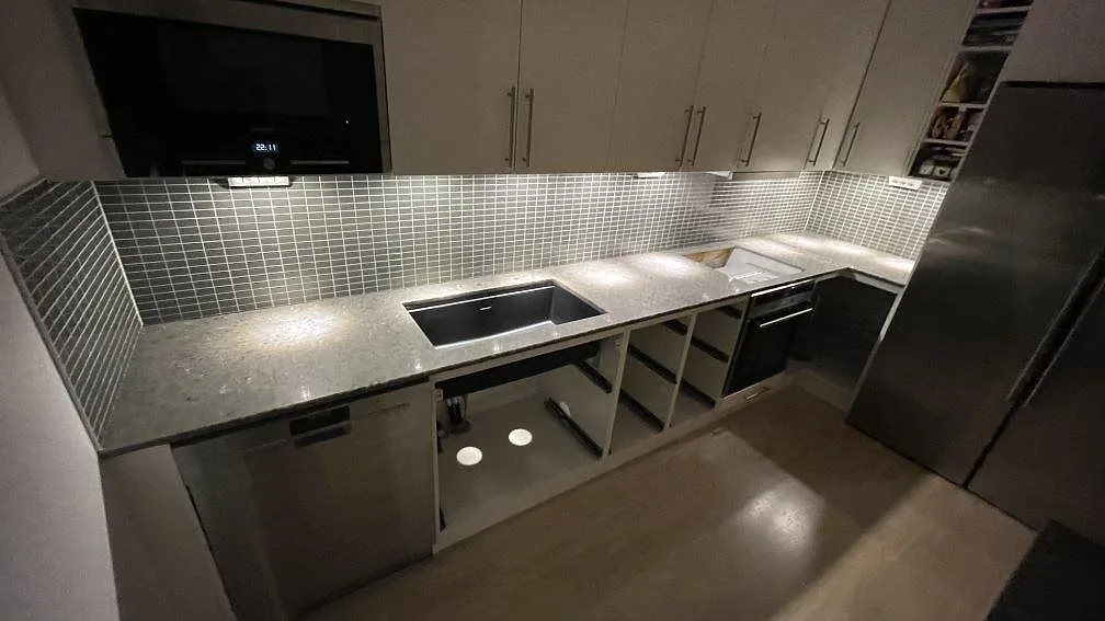 Køkkenbordplade i Silestone Copper Mist, poleret komposit, med underlimmad mørk vask og öppning for kogeplade i ett køkken i Växjö.