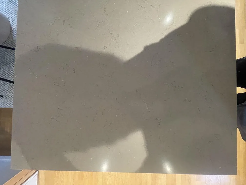 Køkkenbordplade i Silestone Coral Clay, en varm gråbeige kvartskomposit med poleret overflade og diskret åretegning, sedd ovanifrån i ett køkken i Enköping.