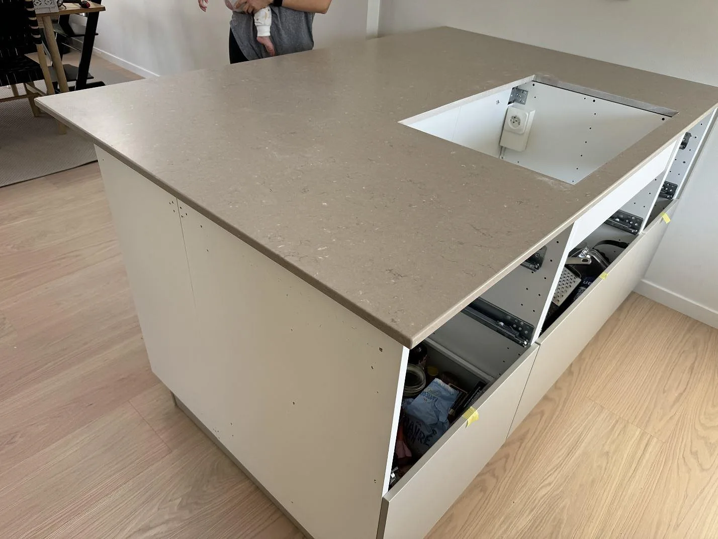 Køkkenbordplade i Silestone Coral Clay, mat Mocka, på en køkkenø med större udskæring og öppna vita skabe i Limhamn.