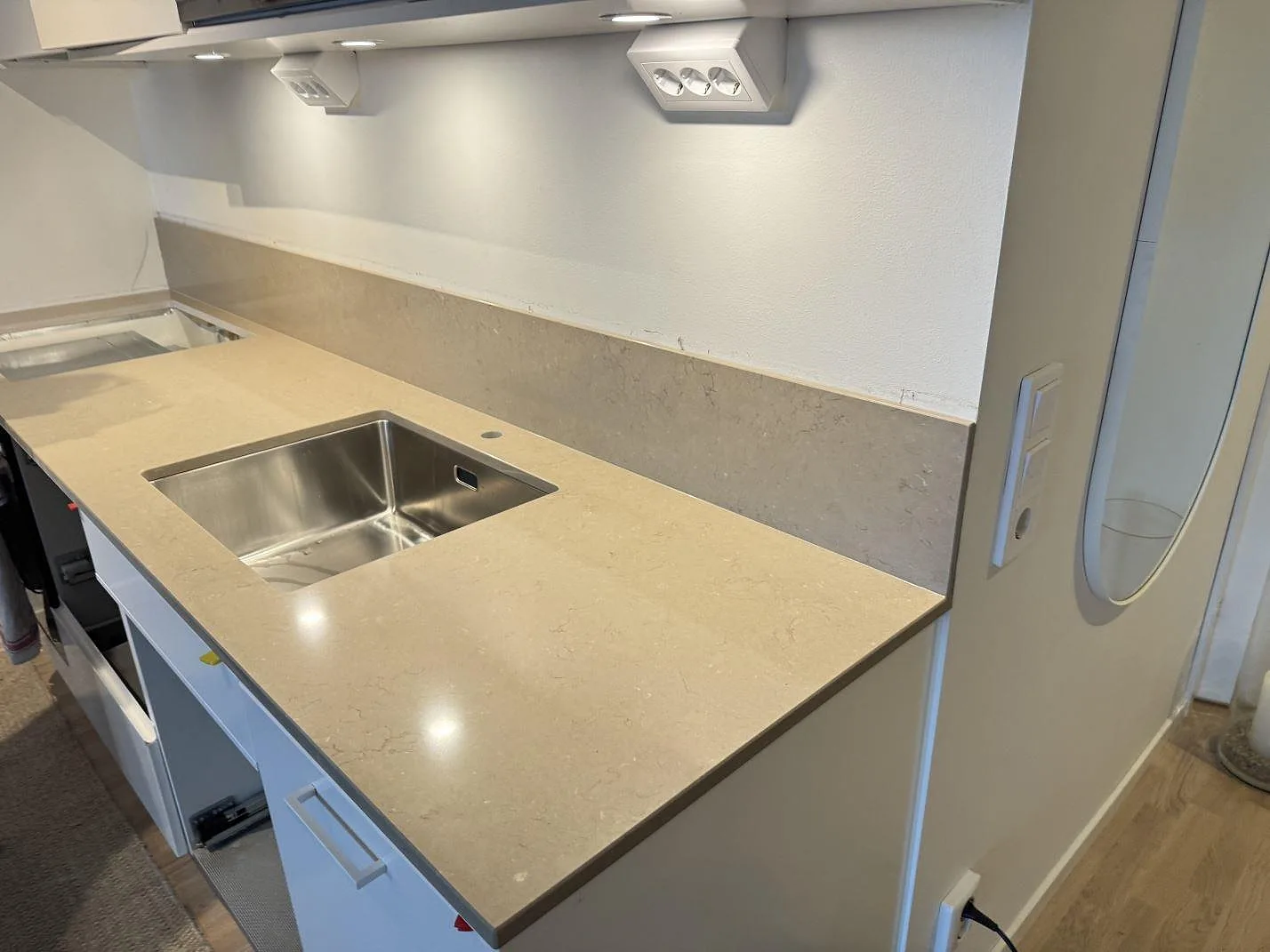 Køkkenbordplade i poleret Silestone Coral Clay med lavt stænkplade og rostfri vask i ett køkken i Limhamn.