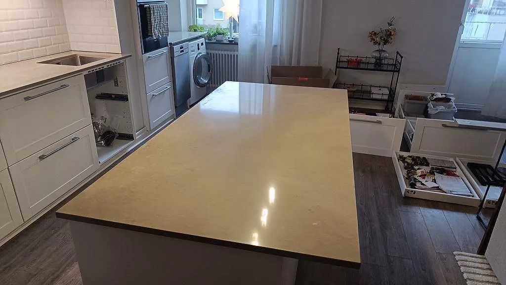 Køkkenø med poleret køkkenbordplade i Silestone Coral Clay, gråbeige kvartskomposit, i ett køkken i Malmö.