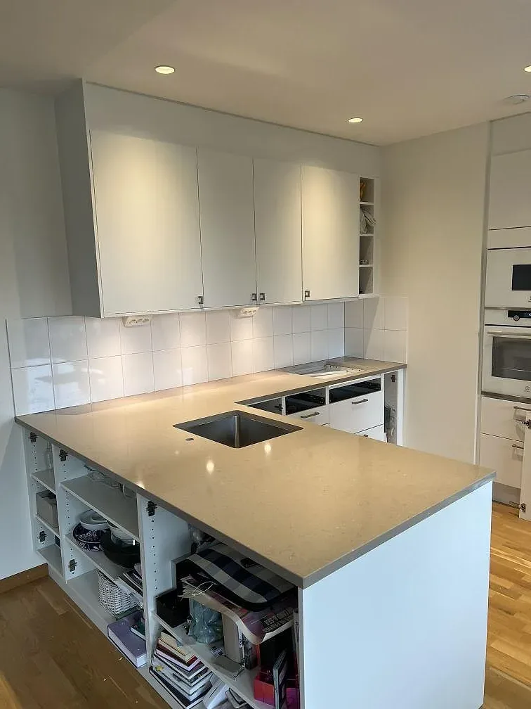 Køkkenbordplade i poleret Silestone Coral Clay, 30 mm kvartskomposit, monteret på öppna köksstommar i ett køkken i Nacka.