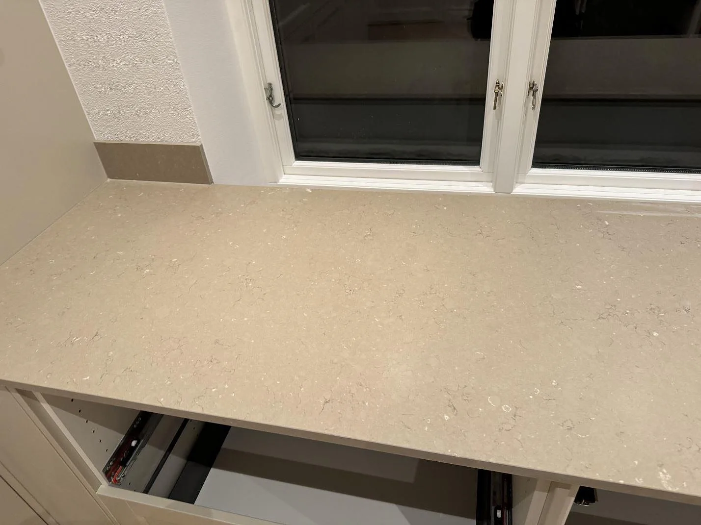 Køkkenbordplade i Silestone Coral Clay, mat Mocka-finish, monteret under ett vindue i ett køkken i Skurup.