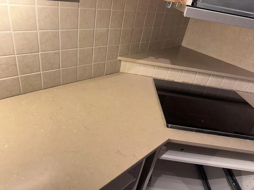 Køkkenbordplade i Silestone Coral Clay, mat Mocka-overflade, med kogeplade og kaklad væg i ett køkken i Strömstad.