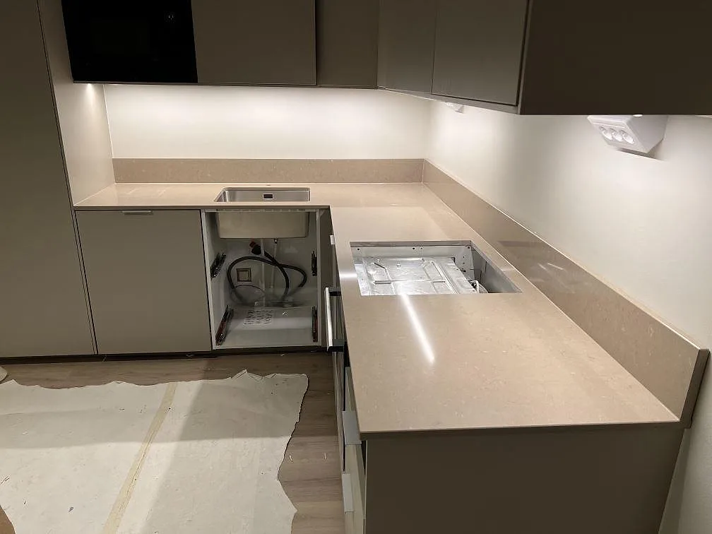 L-formad køkkenbordplade i poleret Silestone Coral Clay, 20 mm komposit, med låg stänkkant i ett køkken i Sundbyberg.