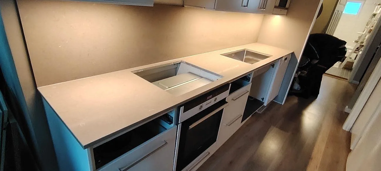 Poleret køkkenbordplade i Silestone Coral Clay, lys kvartskomposit, monteret på öppna köksstommar under montering i Västerhaninge.