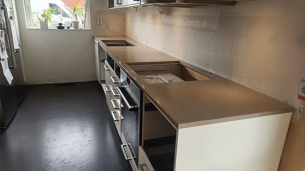Køkkenbordplade i Silestone Coral Clay, poleret kvartskomposit, med hällöppning og vask i ett køkken under montering i Ytterby.