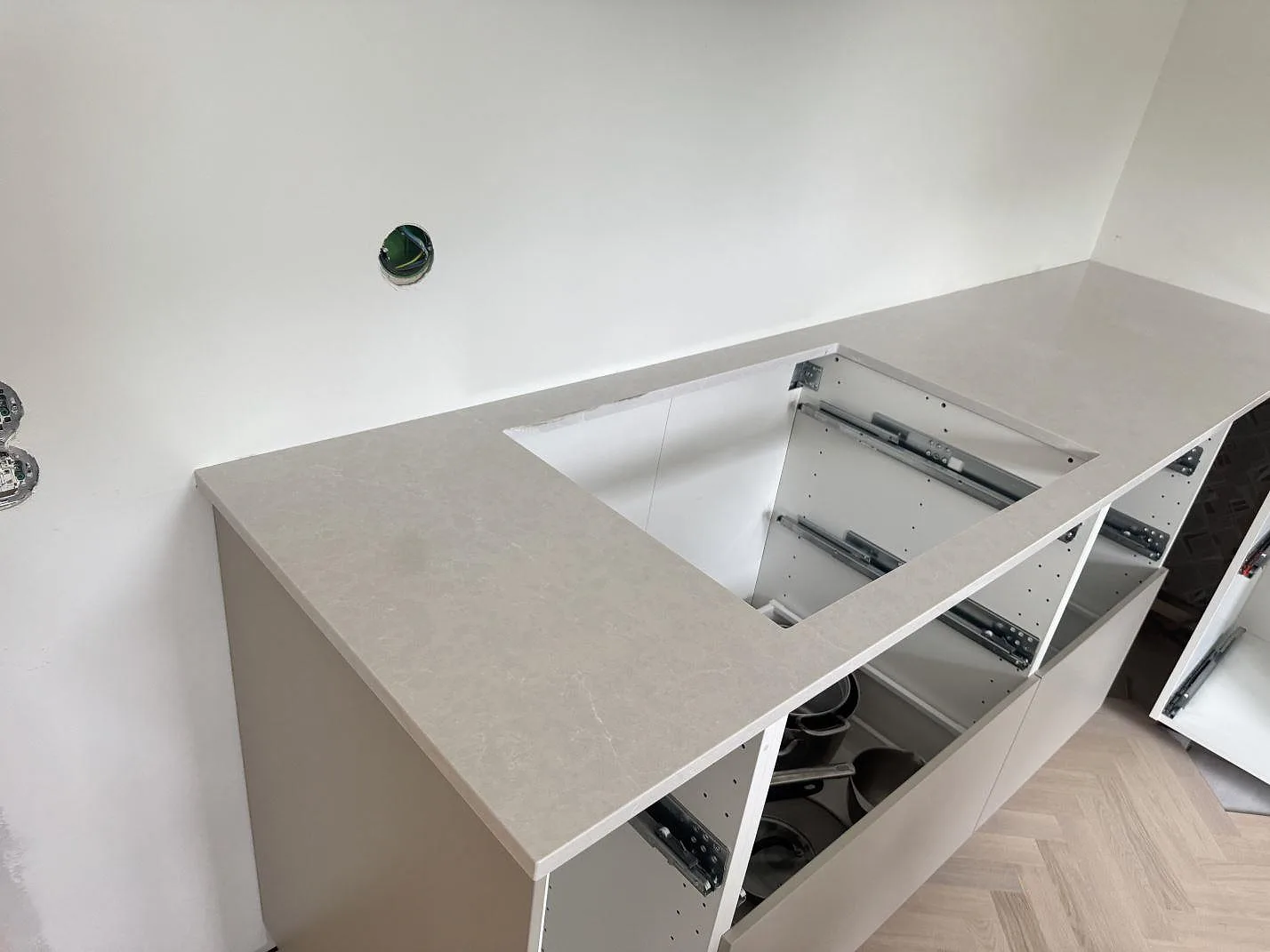 Køkkenbordplade i poleret Silestone Desert Silver med förberett hälluttag og låg stänkkant i ett køkken i Halmstad.