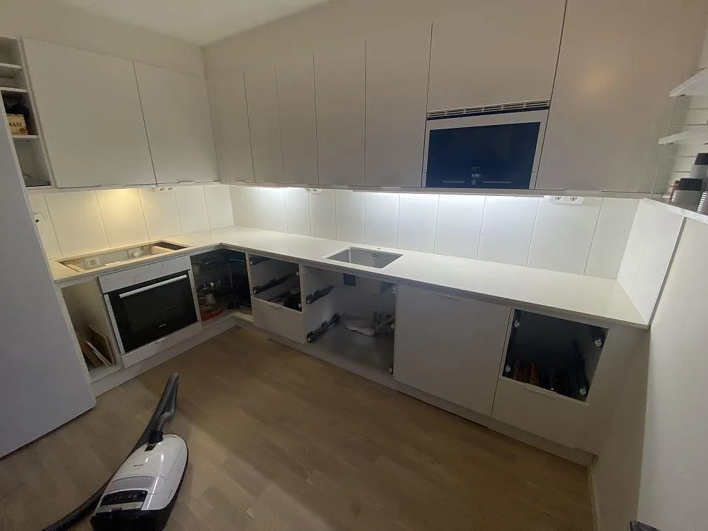 Køkkenbordplade i lys Silestone Eternal Marfil, poleret komposit, med vask og hällöppning i ett køkken i Lomma.