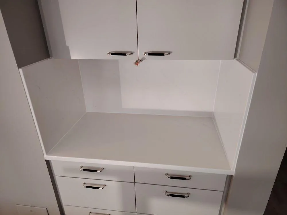 Poleret sidobänk i hvid Silestone Eternal Statuario komposit med uppvikt stænkplade og svag grå åretegning i Frösunda.
