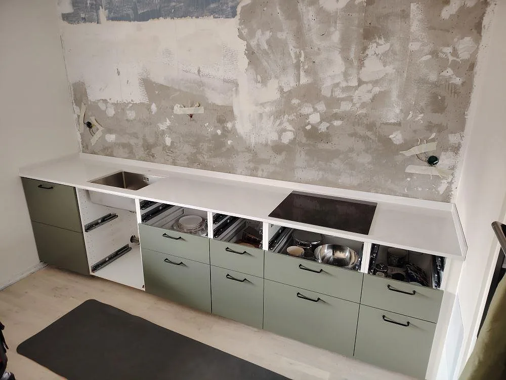 Køkkenbordplade i hvid Silestone Eternal Statuario kvartskomposit, poleret, med vask, kogeplade og låg stänkkant i ett køkken i Stockholm.